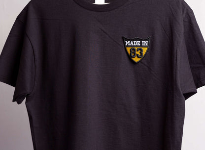 Black t-shirt with a 'Made in 83' logo on a gray background