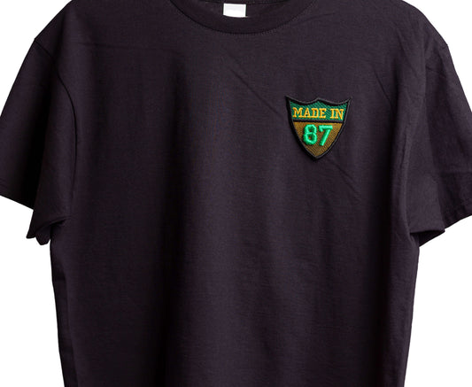 Black t-shirt with a 'Made in 87' patch on a gray background